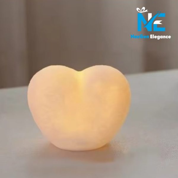 Close-up of heart-shaped 3D LED lamp emitting soft warm light on a light-colored surface, NexGen Elegance logo