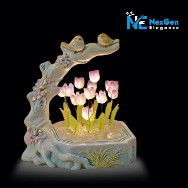 Ceramic-style night lamp with two yellow birds on a branch arching over glowing purple tulip flowers in a decorative base, LED floral night light