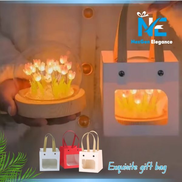 Glowing tulip LED night light in glass dome with wooden base placed next to decorative gift bag, with additional gift bag options in white, red, and beige.